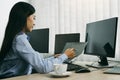 Asian woman software developers sitting in front of computers looking at computer codes on the screen Royalty Free Stock Photo