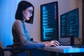 Asian woman software development working on coding computer screen and flowchart at night in modern office