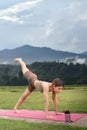 Asian woman sporty practicing yoga at public park outdoor, stretching her body. Healthy active lifestyle