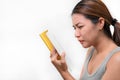 Asian woman squinting with poor eyesight have difficulty reading book on white background, Selective focus on glasses , myopia and