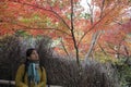 Asian woman is standing among autumn leave and happy with colorful of autumn season