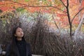 Asian woman is standing among autumn leave and happy with colorful of autumn season