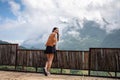 Asian woman standing and enjoying the mountain view on wooden balcony in sunny day Royalty Free Stock Photo