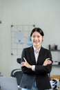 Asian woman standing on front desk while holding coffee cup and looking Royalty Free Stock Photo