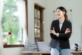 Asian woman standing on front desk while holding coffee cup and looking Royalty Free Stock Photo