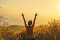 Asian woman standing and hand up and show i love you hand gesture sign in tropical forest and looking far away at sunrise time