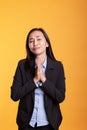 Asian woman standing with hands in praying gesture