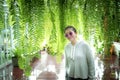 Asian woman standing at home terrace with green fern leaves background