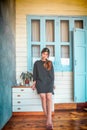 Woman standing infront of the pastel wooden house