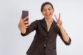 asian woman standing with peace hand gesture while taking selfie photo Royalty Free Stock Photo