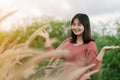 Asian woman Standing smiling in the fields of brown grass in the morning sun With a happy face Royalty Free Stock Photo