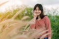 Asian woman Standing smiling in the fields of brown grass in the morning sun With a happy face Royalty Free Stock Photo