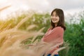 Asian woman Standing smiling in the fields of brown grass in the morning sun With a happy face Royalty Free Stock Photo