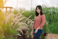 Asian woman Standing smiling in the fields of brown grass in the morning sun With a happy face Royalty Free Stock Photo