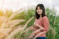 Asian woman Standing smiling in the fields of brown grass in the morning sun With a happy face Royalty Free Stock Photo