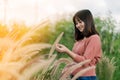 Asian woman Standing smiling in the fields of brown grass in the morning sun With a happy face Royalty Free Stock Photo