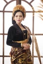 Asian woman wearing black Balinese Kebaya on large window background