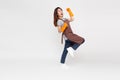 Asian woman standing and wearing orange rubber gloves for hands protection during cleaning.