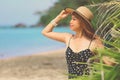 asian woman with straw hat hat posing near palm trees Royalty Free Stock Photo