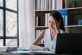 Asian woman stressed while working on laptop, Tired asian businesswoman with headache at office, feeling sick at work Royalty Free Stock Photo