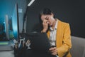 Asian woman is stressed while working on laptop, tired asian businesswoman with headache at office, feeling sick at work, Stressed Royalty Free Stock Photo