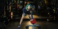 Asian woman with strong and muscular body training on bent over row dumbbell with bench staring at the camera to build back and