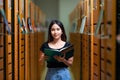 Asian woman student read text book in her university library Royalty Free Stock Photo