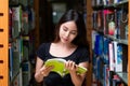 Asian woman student read text book in her university library Royalty Free Stock Photo