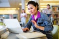 Asian woman student studies in the library on a laptop Royalty Free Stock Photo