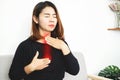 Asian woman suffering from acid reflux or gastroesophageal reflux disease GERD feeling uncomfortable and burning chest