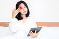 Asian woman suffering from eye pain , tired eyes from watching blue light screen of tablet