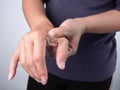 Asian woman suffering finger joint pain that are sign of Rheumatoid Arthritis or gout symptom. Health care and medical concept