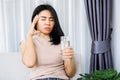 Asian woman suffering from headache after drinking cold water hand holding her head and glass of water Royalty Free Stock Photo