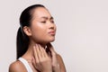 Asian woman suffering from sore throat, touching her neck Royalty Free Stock Photo