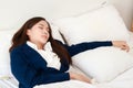 Asian woman in a suit lying on the bed. Female employees work overtime. Royalty Free Stock Photo