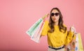 Asian woman in sunglasses, holding shopping bags with delight Royalty Free Stock Photo