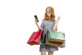 Asian woman with sunglasses using the mobile phone while carrying shopping bags Royalty Free Stock Photo