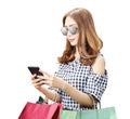 Asian woman with sunglasses using the mobile phone while carrying shopping bags Royalty Free Stock Photo