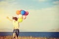 asian woman on sunset grassland with colored balloons Royalty Free Stock Photo