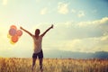 Asian woman on sunset grassland with colored balloons Royalty Free Stock Photo