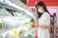 Asian women and surgical mask shopping some food in supermarket, covid-19 crisis Royalty Free Stock Photo