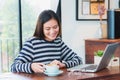 Asian woman take a break from using on laptop computer and drink Royalty Free Stock Photo