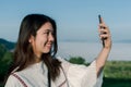 Asian woman  take a selfie phone,  in the tourist area behind the fog and mountains with a smiling face take a selfie phone Royalty Free Stock Photo