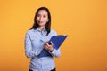 Asian woman taking notes on blue clipboard with pen Royalty Free Stock Photo