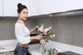 Asian woman taking photo with flowers in kitchen Royalty Free Stock Photo