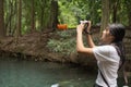 Asian woman taking photos in autumn forest Royalty Free Stock Photo