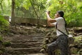 Asian woman taking photos in autumn forest Royalty Free Stock Photo