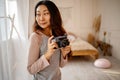 Asian woman taking pictures with old film camera. woman Photographer making pictures with retro camera having fun at home. Royalty Free Stock Photo