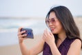 Asian woman taking selfie with mobile phone - lifestyle photo of young happy and beautiful Korean girl taking self portrait on Royalty Free Stock Photo