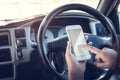 Asian woman talk by mobile calling texting and looking on a cellular phone while sitting in her car, driving under the influence, Royalty Free Stock Photo